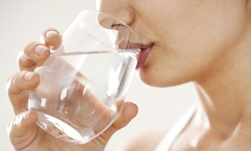 グラスで水を飲む女性の口元